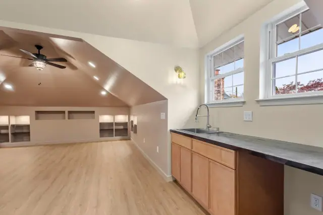 Finished attic conversion with sloped ceilings, new flooring and a built in kitchenette
