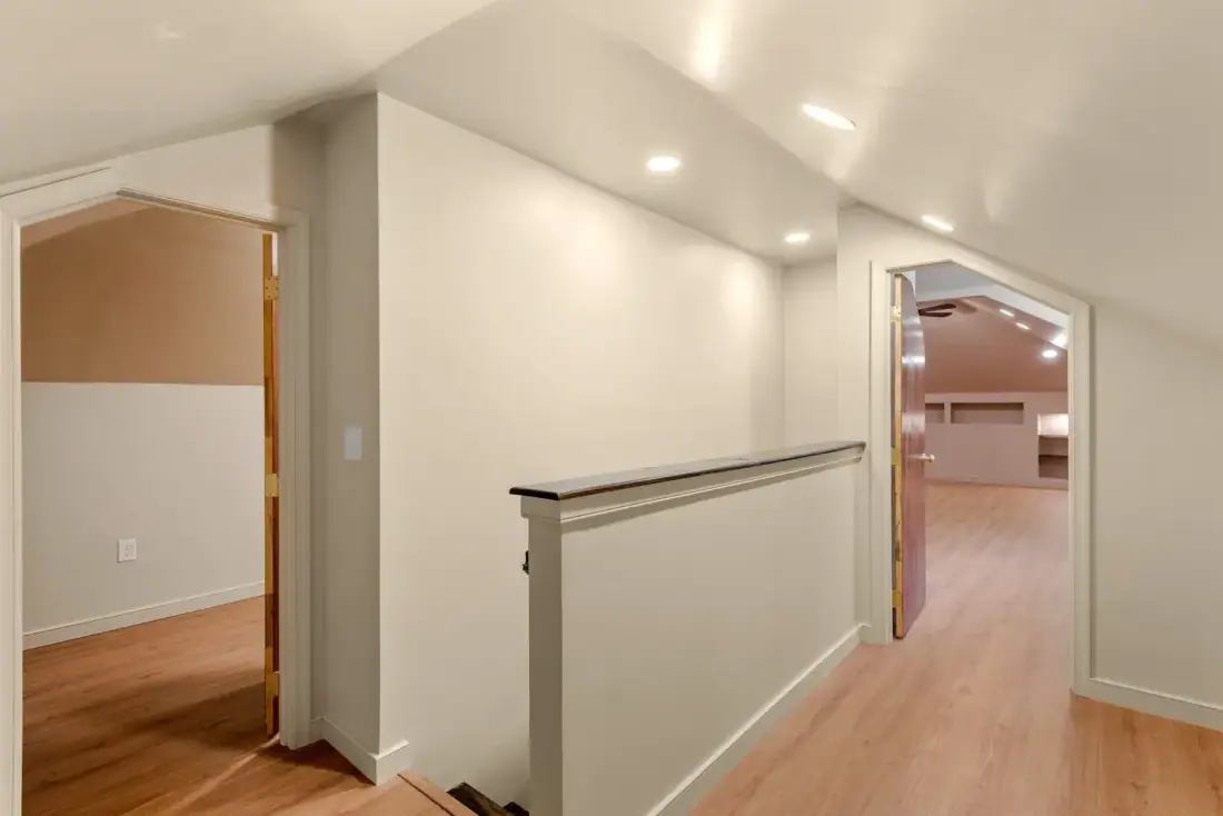 Attic stair landing opening into a finished upper floor with arched doorways
