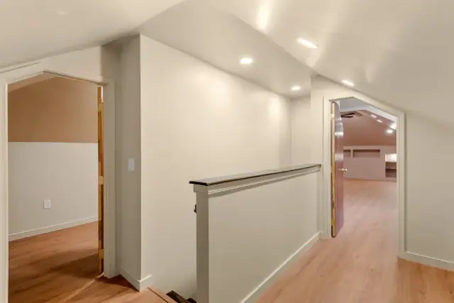 Attic stair landing opening into a finished upper floor with arched doorways