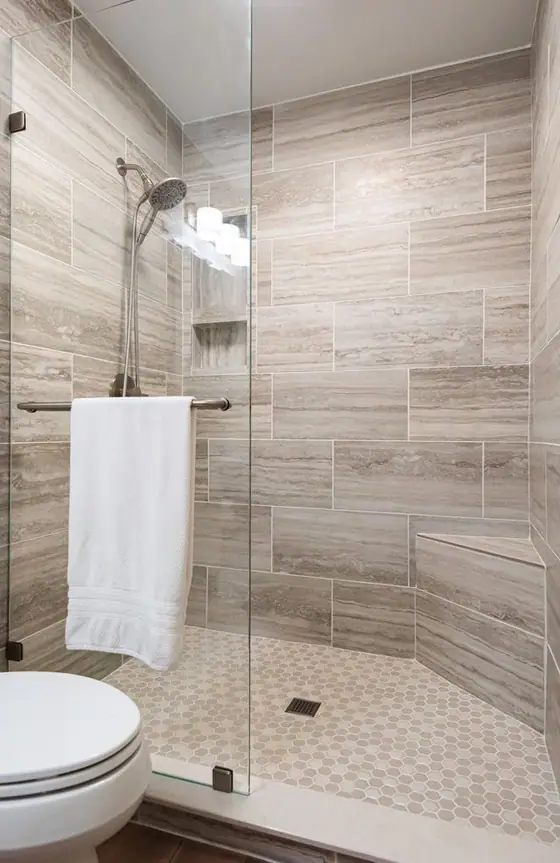 Frameless glass shower door with gray wood look tile walls