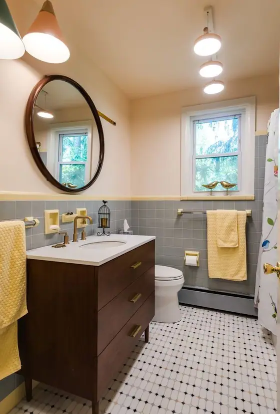 Bathroom with a walnut vanity, round mirror, globe pendant lights and basketweave floor tile