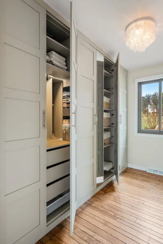Built in closet system with open shelving, drawers and a crystal chandelier