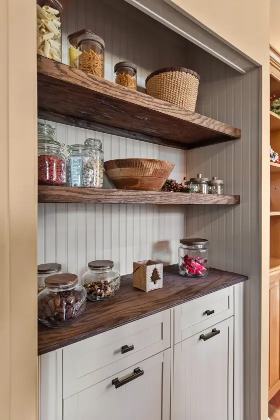 Pantry nook with open wood shelves above white base cabinets