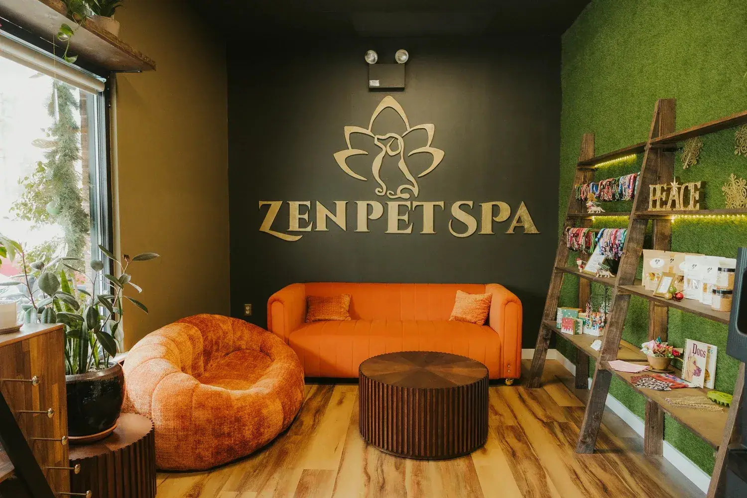 Zen Pet Spa lounge with a moss wall, gold logo sign and an orange sofa