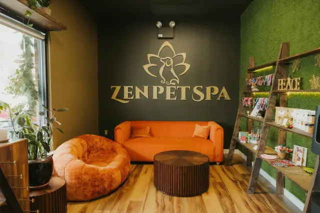 Zen Pet Spa lounge with a moss wall, gold logo sign and an orange sofa