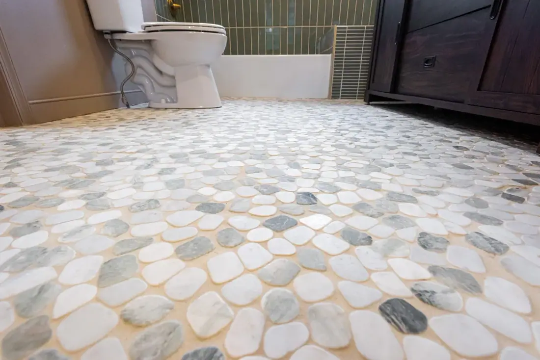 White and gray marble pebble mosaic floor in a remodeled bathroom